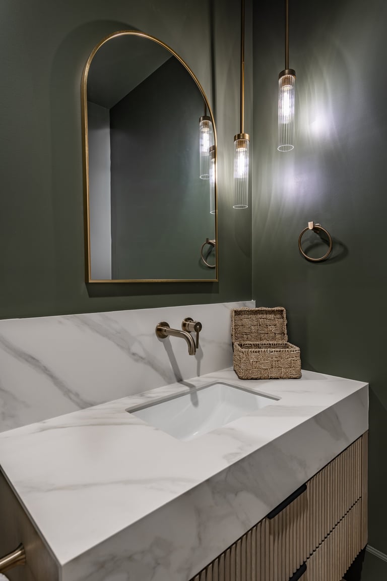 Elegant powder room with furniture-style vanity, decorative mirror, designer light fixture, and statement wallpaper or tile