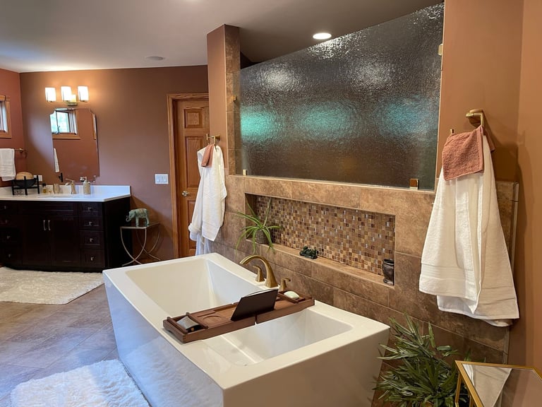 Luxury bathroom with freestanding white soaking tub, mosaic tile shower, dark vanity, and spa-like finishes