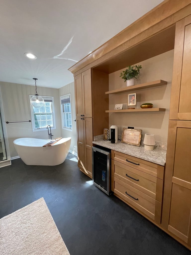 Modern bathroom with freestanding soaking tub, wooden cabinetry with shelves, granite countertop, and dark flooring